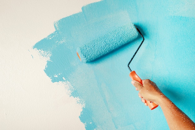 Roller Brush Painting, Worker schilderij op oppervlaktemuur Schilderen appartement, renoveren met blauwe kleur verf.