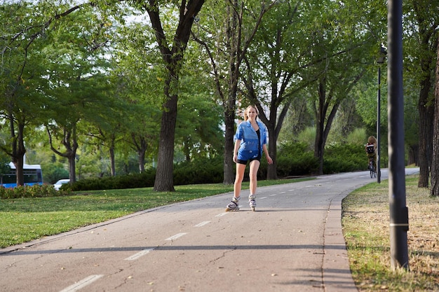 Roller skating girl in park rollerblading on inline skates