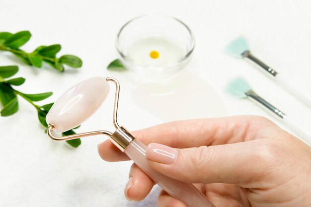 Roller voor Gua Sha massage in vrouwelijke hand close-up