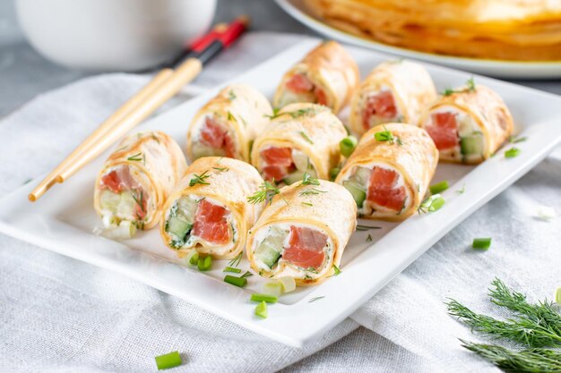 Rolletjes dunne pannenkoekjes met gerookte zalm en roomkaas. Gevulde pannenkoeken. Maslenitsa