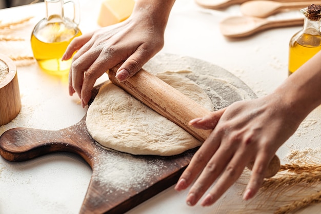 Rolling out the dough with rolling pin for pizza