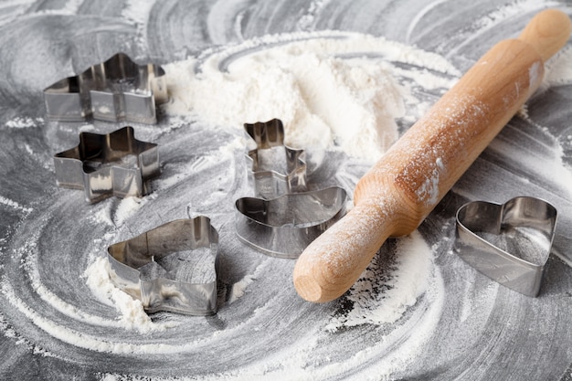 Rolling pin and flour on black table