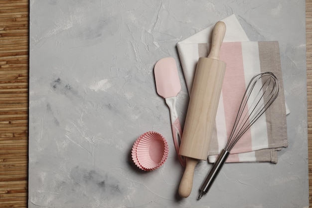 Rolling pin and whisk with cupcake cases on a gray background. Baking concept. Place for text.