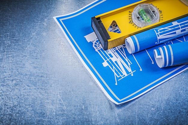 Photo rolls of blue construction drawings level on metallic background