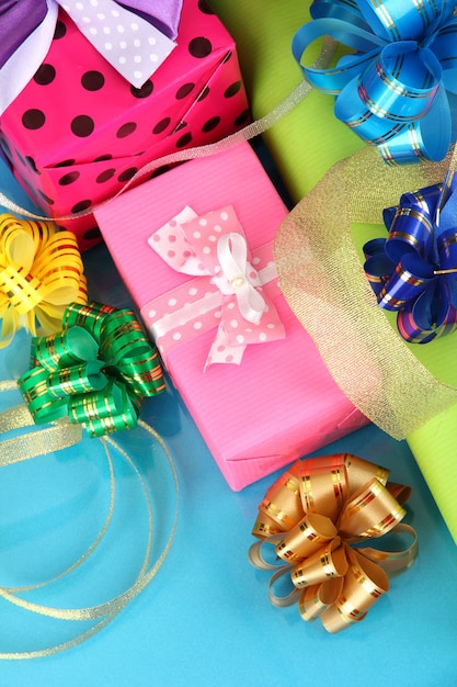 Рулоны рождественской оберточной бумаги с лентами, бантами на цветном фоне