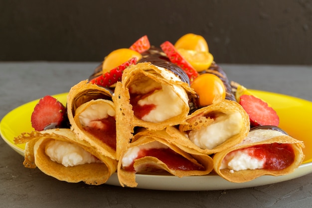 Rolls of pancakes with curd filling. gray background.