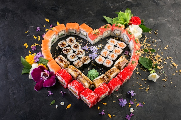 Photo rolls and sushi on a black slate background, japanese cuisine