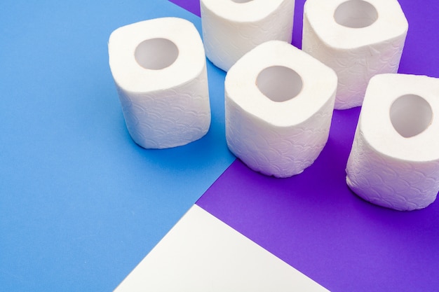 Рулоны туалетной бумаги на цветном фоне, вид сверху