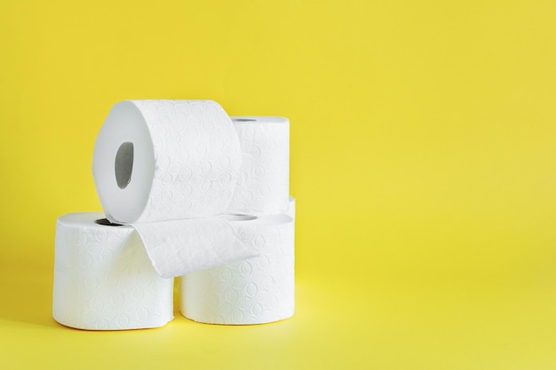 Photo rolls of toilet paper on yellow color background