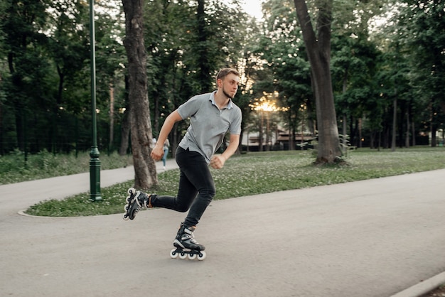 Rolschaatsen, mannelijke schaatser die in actie rolt. rolschaatsen in de stad, actieve extreme sporten buitenshuis, vrije tijd voor jongeren, rolschaatsen