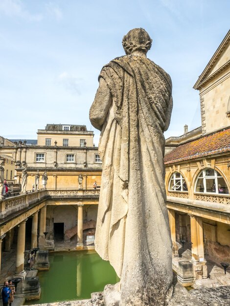 Roman Bath, de UNESCO-werelderfgoedlocatie met groene waterreflectie onder bewolkte hemel in Engeland