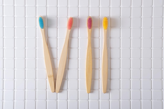 Roman numeral VII composed of toothbrushes on a white tiled background