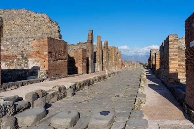 Римская дорога с изношенными камнями по проходу лошадиных телег в археологическом парке Помпеи