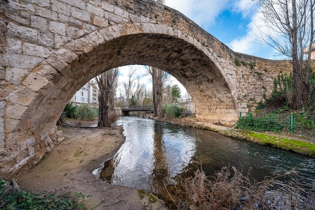 Photo roman stone bridge over a small stream that crosses the city of aranda de duero burgos