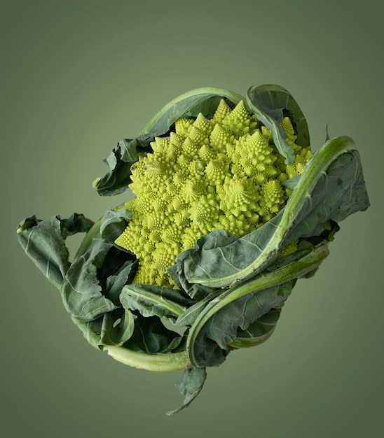 Photo romanello cabbage on green background food levitation