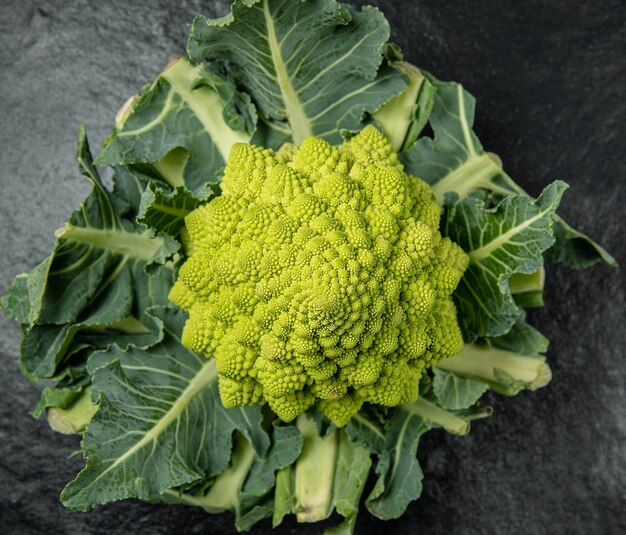 Romanesco broccoli head on a dark stone surface