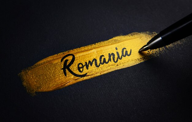 Romania Handwriting Text on Golden Paint Brush Stroke