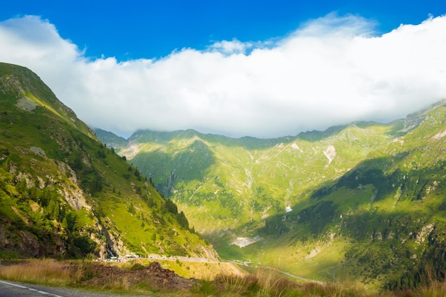 여름 화창한 날에 루마니아어 대로 산입니다. Transfagarasan 고산 산악 도로, Fagaras Mountains, Transylvania, Romania에서 산과 흐린 하늘의 놀라운 전망. 여행 배경