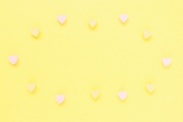 Photo romantic abstract pastel yellow background with wooden hearts decoration