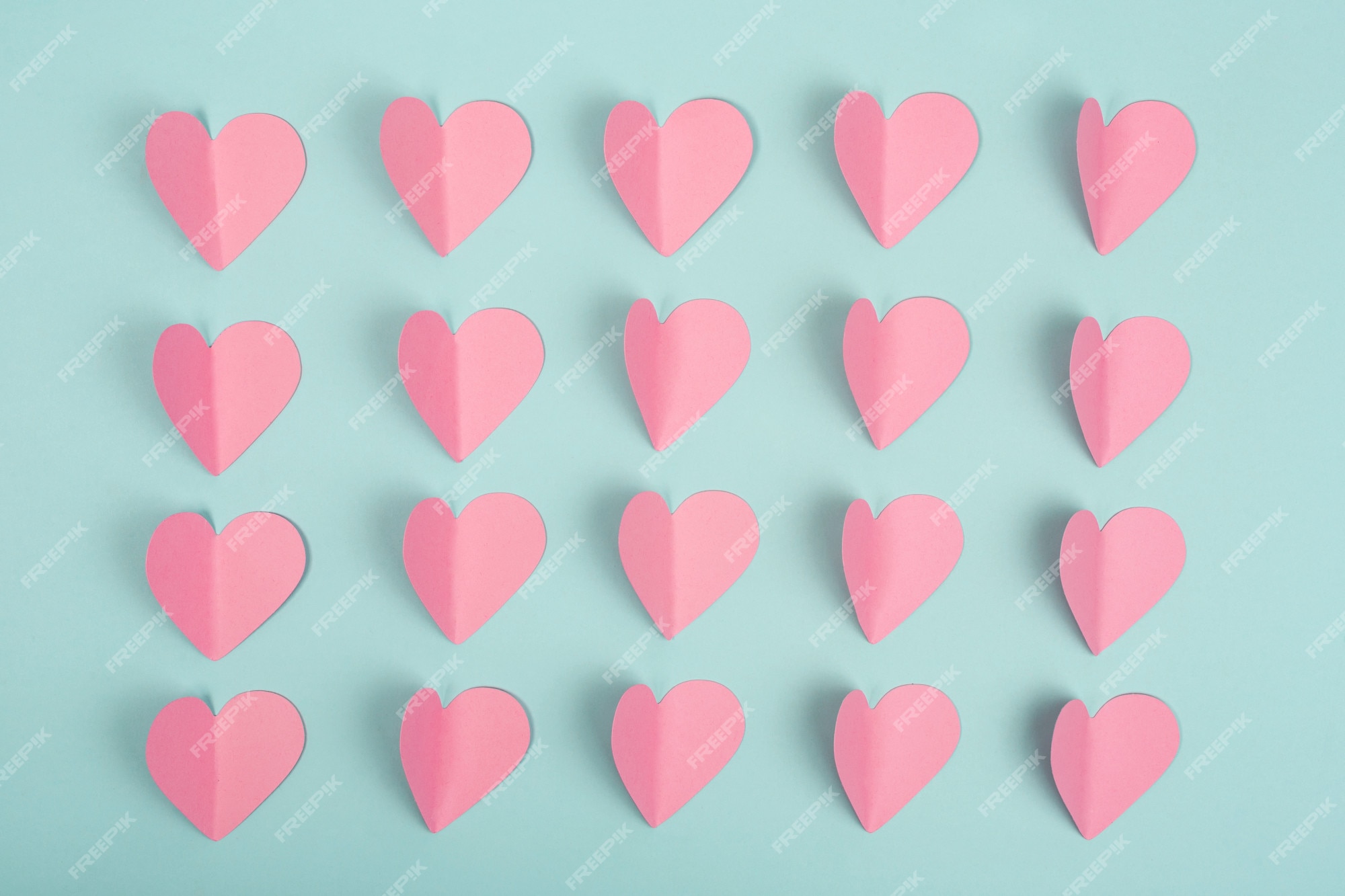 Premium Photo | Romantic background made of pink paper hearts on blue background. paper cut pink hearts Premium Photo | Romantic background made of pink paper hearts on blue background. paper cut pink hearts