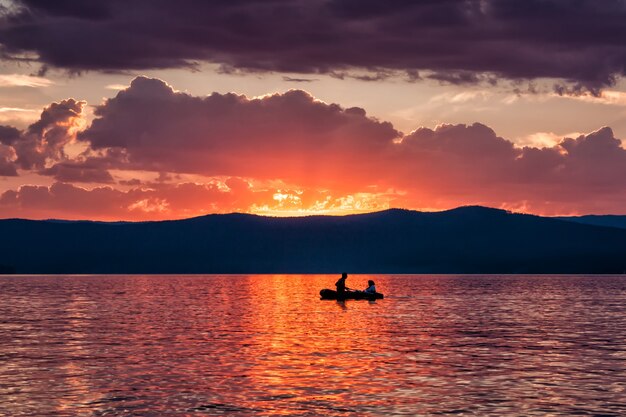 Romantic boat rides on the lake against the backdrop of the evening dawn