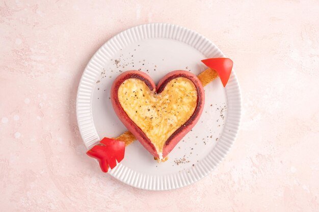 Romantic breakfast fried eggs in heart shaped sausages