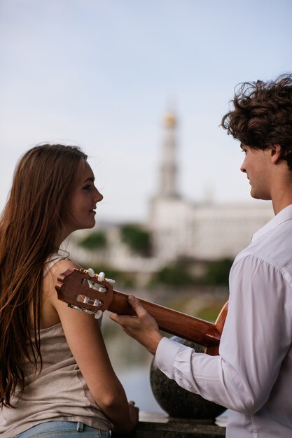 Concetto romantico di musica della chitarra delle coppie della data della città. serenata per l'amato. felici insieme.