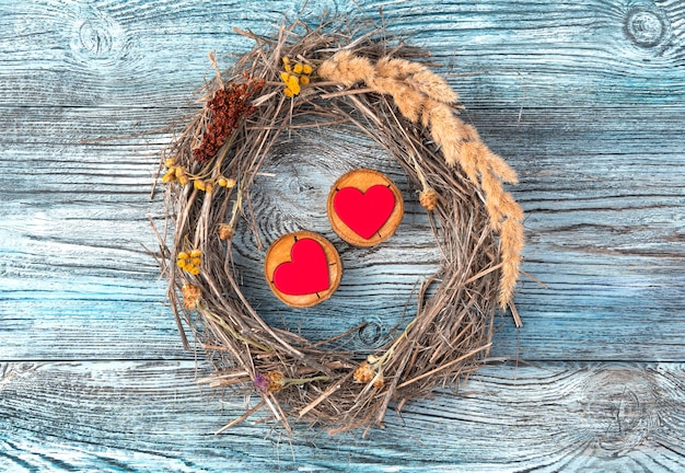 Romantic composition of two hearts and a frame on a wooden background.