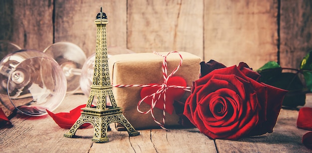 Composizione romantica con rosa rossa, confezione regalo e giocattolo torre eiffel