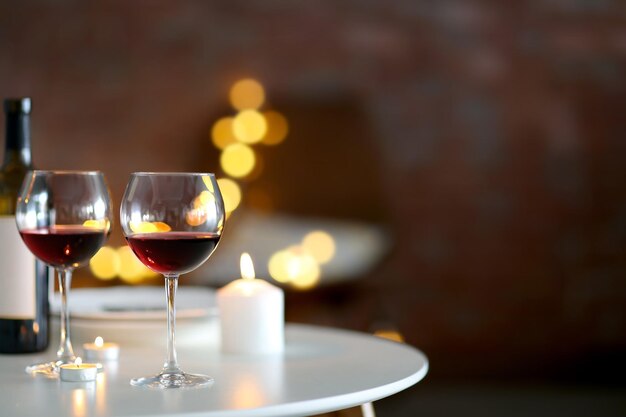 Romantic composition with wine and candle on blurred background