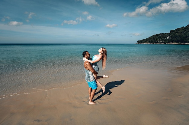 Una coppia romantica sulla spiaggia in costume da bagno, bei giovani sexy. phuket. tailandia.