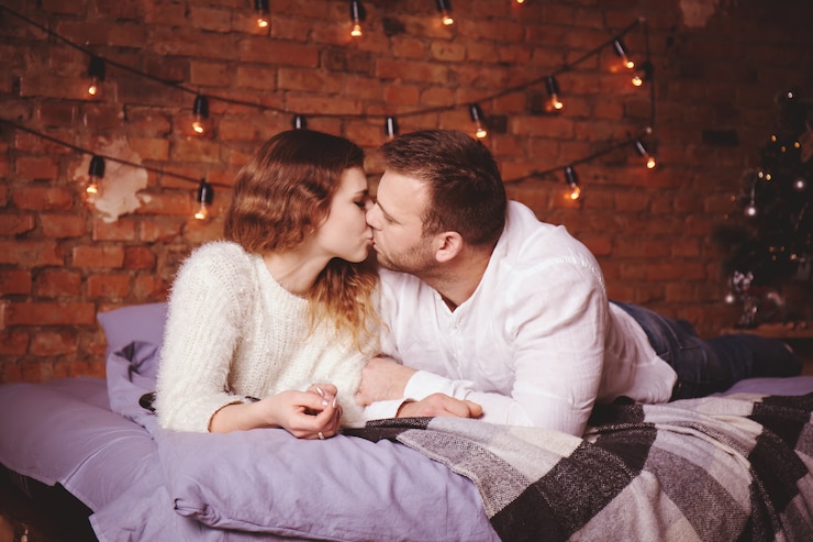 Photo romantic couple in bed against a brick wall