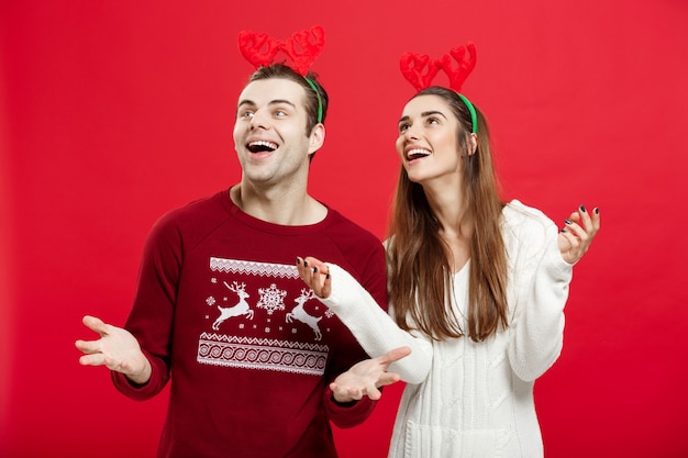 Romantic couple in a christmas sweaters waiting for snow.