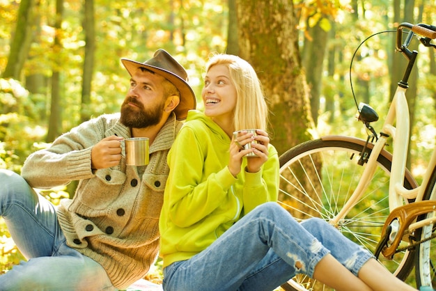 Romantic couple on date Date and love Autumn date hike in forest Romantic date with bicycle Couple in love ride bicycle together in forest park Bearded man and woman relaxing in autumn forest