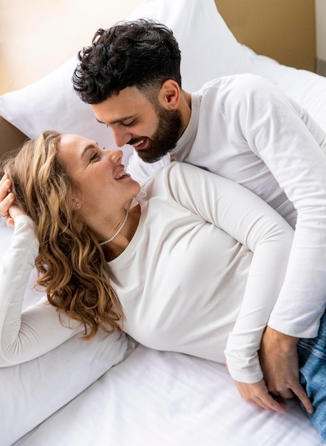 Romantic couple embraced in bed at home