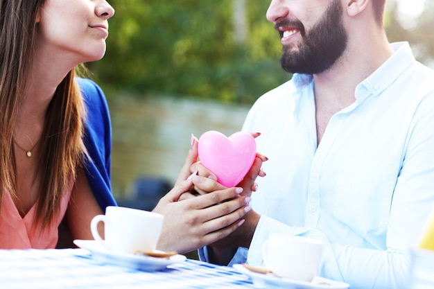 Photo romantic couple holding hands in cafe