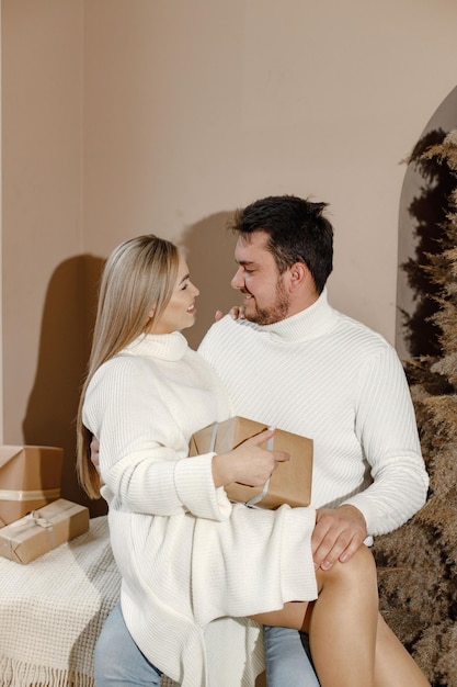 Romantic couple hugging near Christmas tree at home