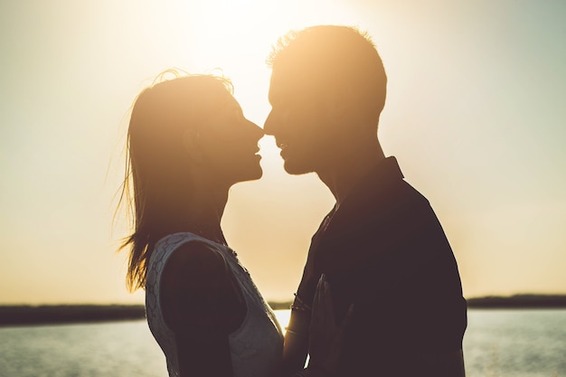 Romantic couple kissing outside at sunset