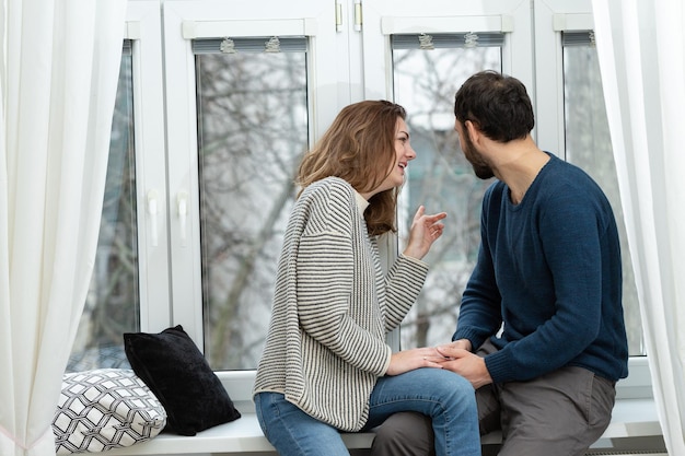 Romantic couple looking out of the window Quarantine at home
