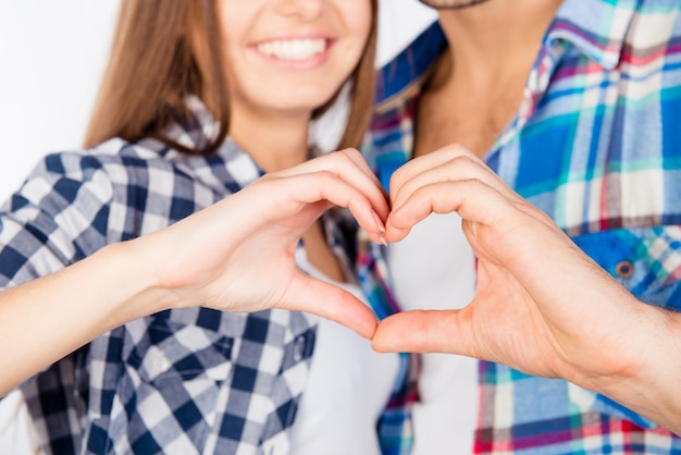 Romantic couple in love gesturing a heart with fingers