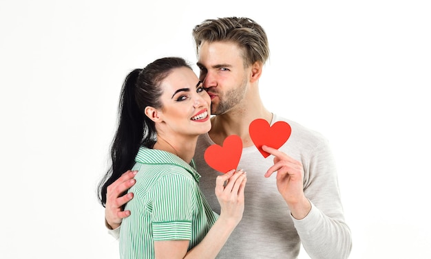 Romantic couple in love hug. Handsome unshaven man and pretty girl in love. Valentines day and love. Romantic feelings concept. Man and woman couple in love hold red heart card on white background.