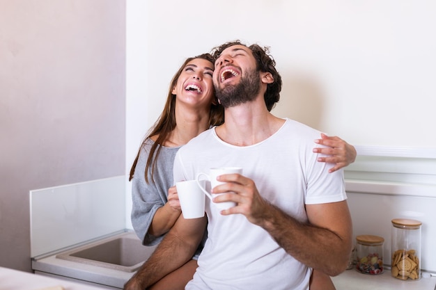 Romantic couple in love spending time together in kitchen Cute young couple drinking coffee in kitchen and enjoying morning time together