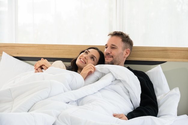 Romantic couple lover hugging on winter morning in bed at home