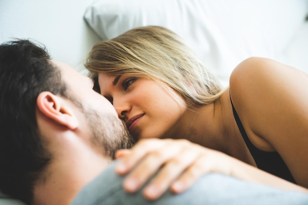 Photo romantic couple lying on bed at home