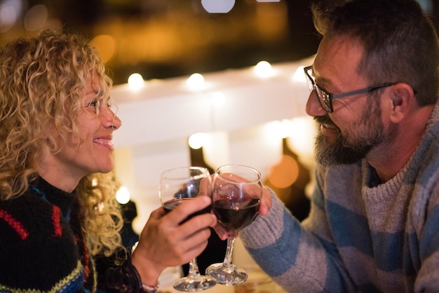 Романтическая пара из двух взрослых вместе празднует годовщину, едят и пьют вино в ресторане ночью