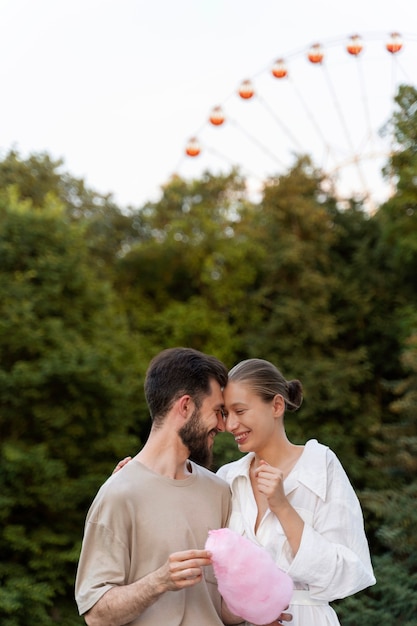 Foto coppia romantica insieme alla ruota panoramica nel parco