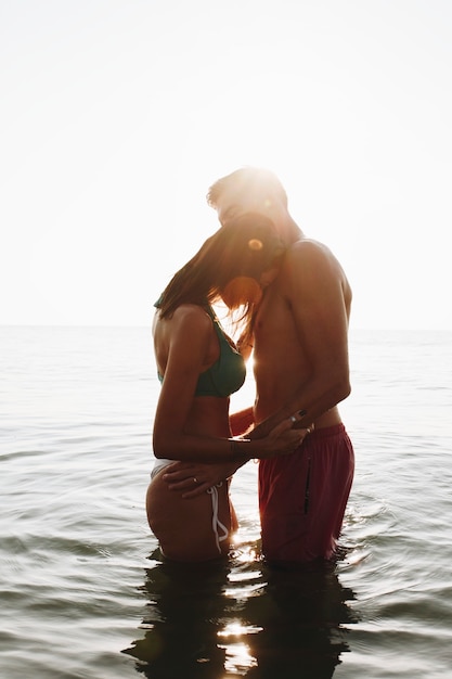 Photo romantic couple in the sea at sunset