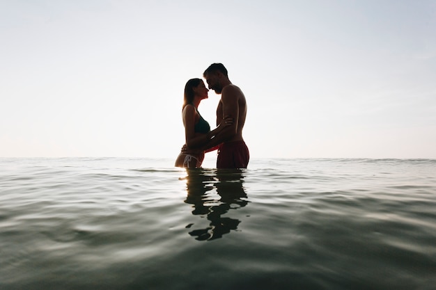 Romantic couple in the sea at sunset