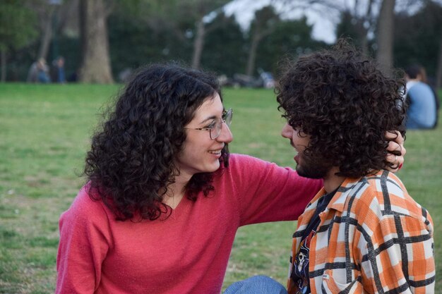 Romantic couple sitted at the park talking and caressing