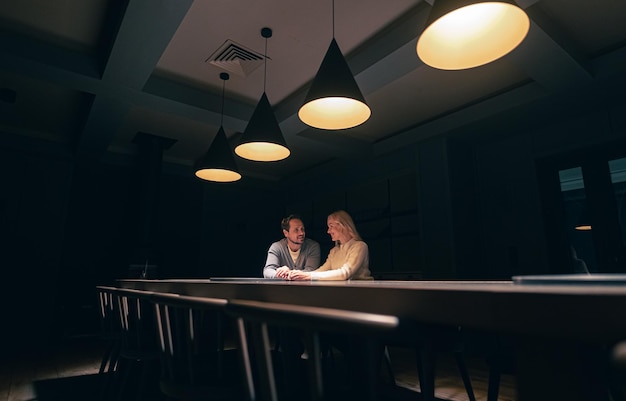 The romantic couple sitting at the table in empty night restaurant